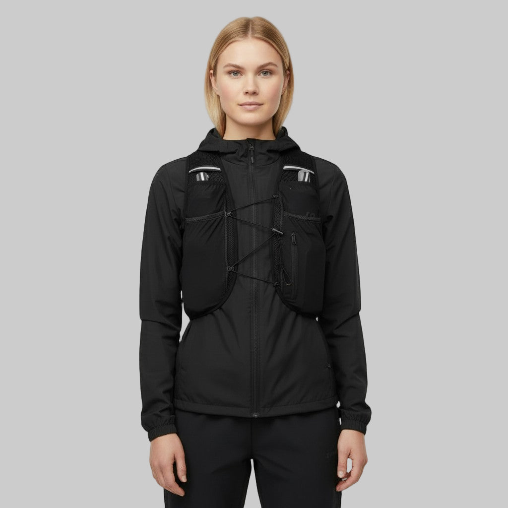 Kvinde iført sort løbevest over sort løbejakke, vist forfra med lommer og snørresystem