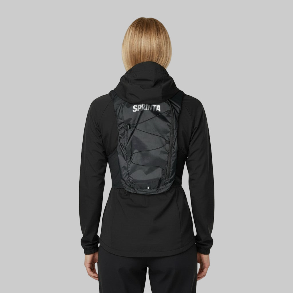 Kvinde med sort løbevest set bagfra, med SPRINTA-logo og justerbare elastikker