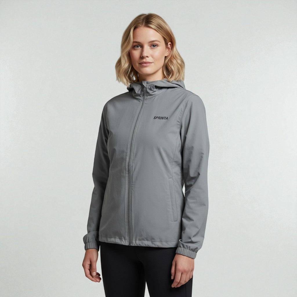 Kvinde ifoert graa Sprinta letvaegtsjakke – vindtæt, vandafvisende og perfekt til loeb og udendoerstræning.