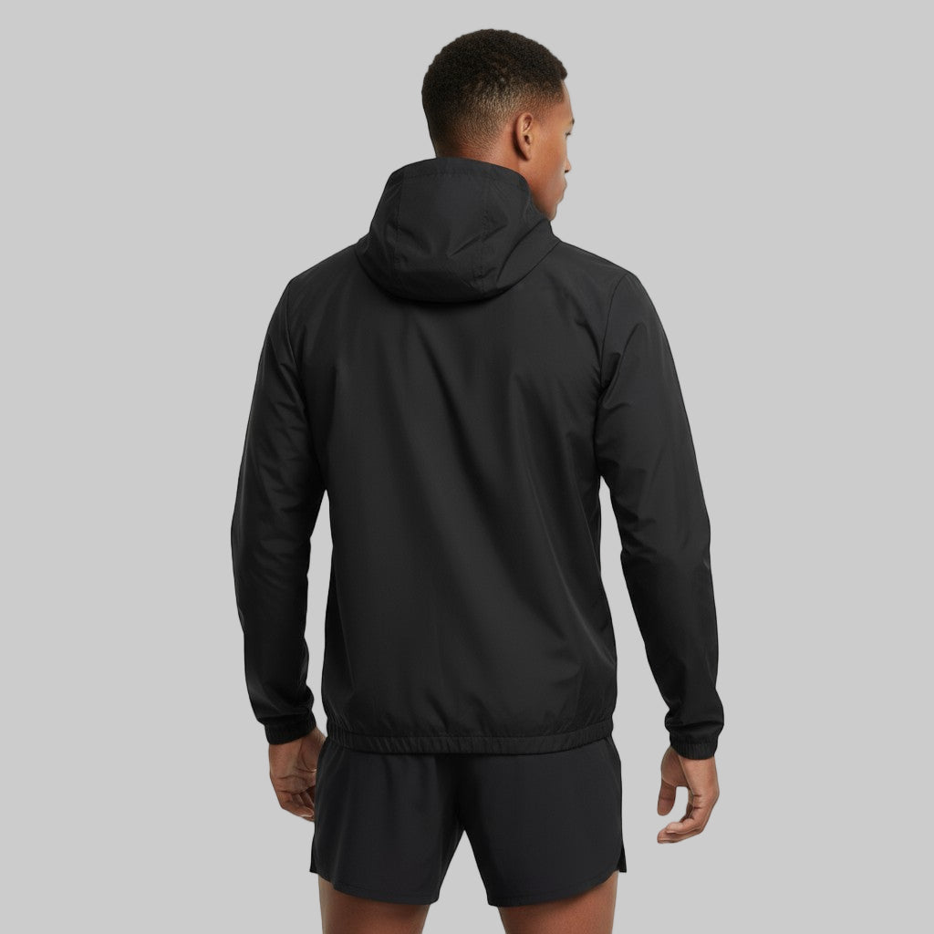 Mand set bagfra iført sort Sprinta letvægts jakke og løbeshorts i et lyst studiemiljø.