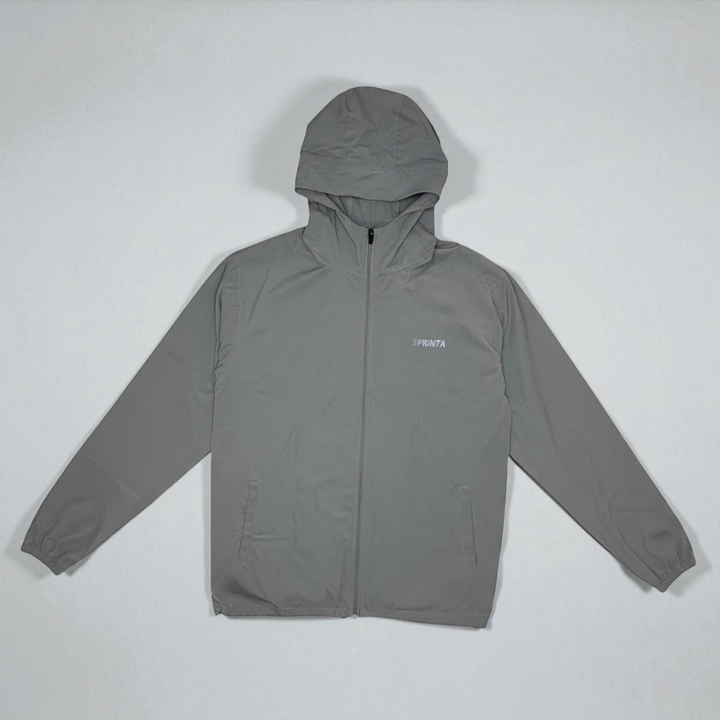 Sprinta Letvægtsjakke i grå – vindtæt og vandafvisende løbejakke med hætte, lynlås og to lommer, designet til både løb og cykling med let vægt og åndbart materiale