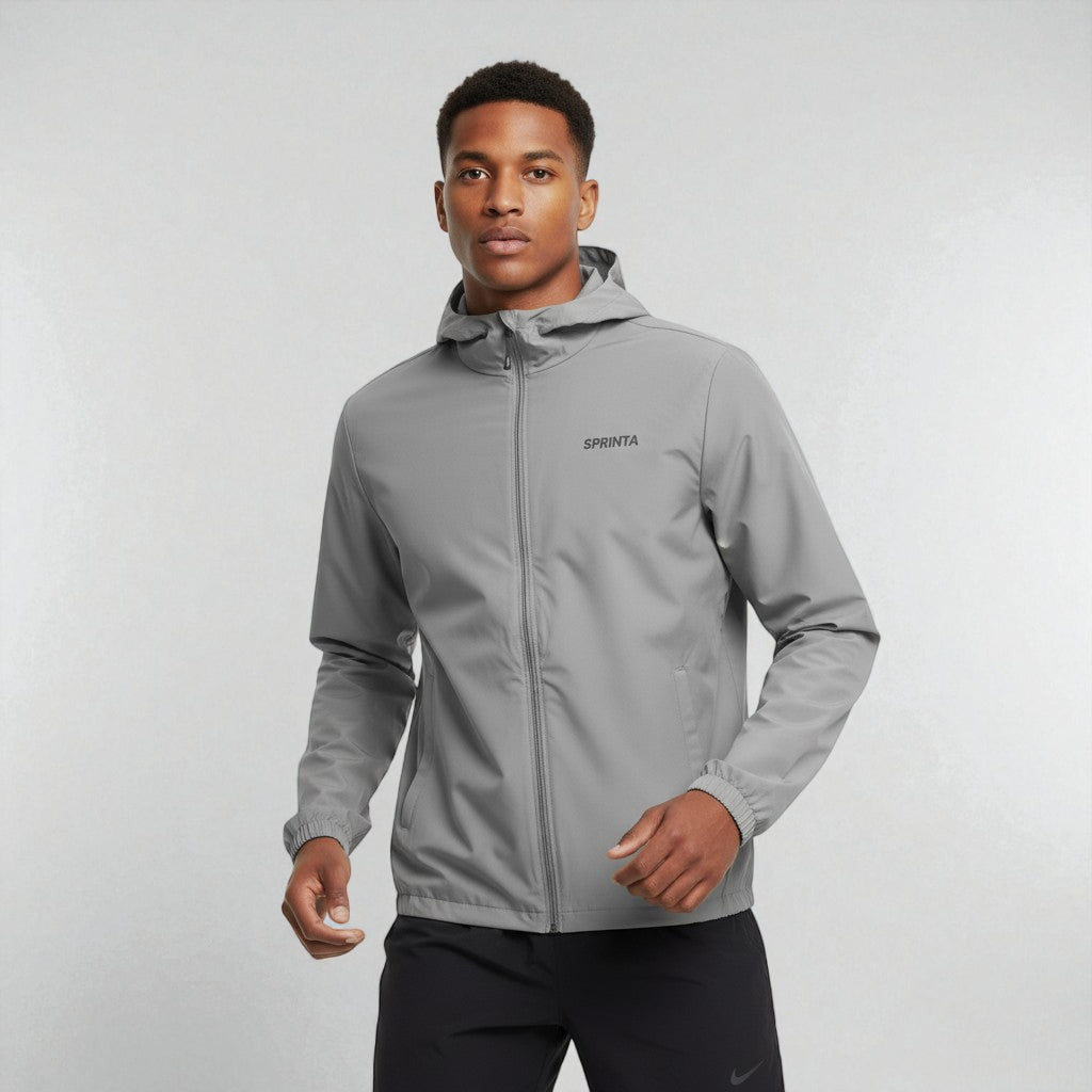 Mand iført graa Sprinta letvaegtsjakke under traening – vindtæt, vandafvisende og designet til loeb og cykling.