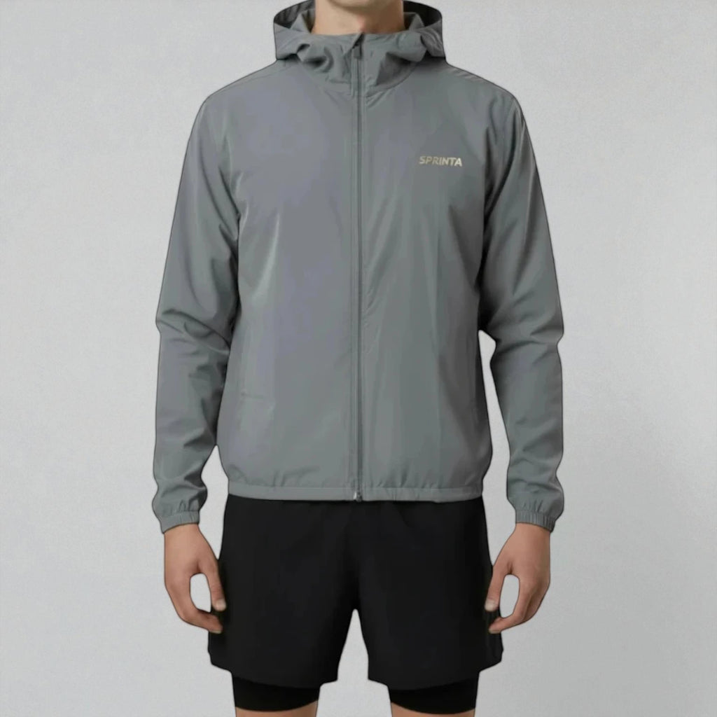 Mand iført Sprinta Letvægtsjakke i grå – ultralet og vindtæt løbejakke med hætte og lynlås, skabt til både løb og cykling med høj komfort, bevægelsesfrihed og sporty pasform