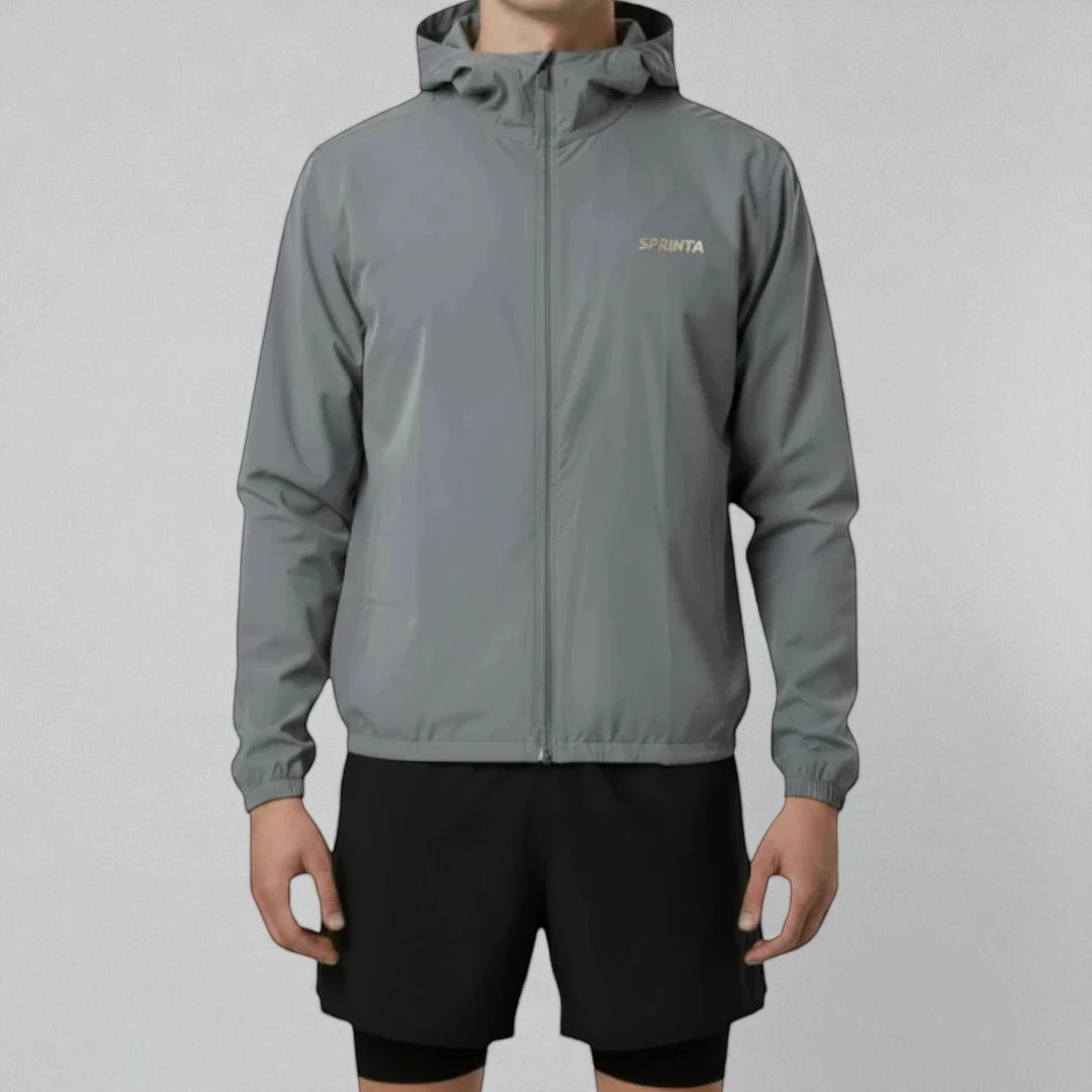 Mand iført Sprinta Letvægtsjakke i grå – ultralet og vindtæt løbejakke med hætte og lynlås, skabt til både løb og cykling med høj komfort, bevægelsesfrihed og sporty pasform