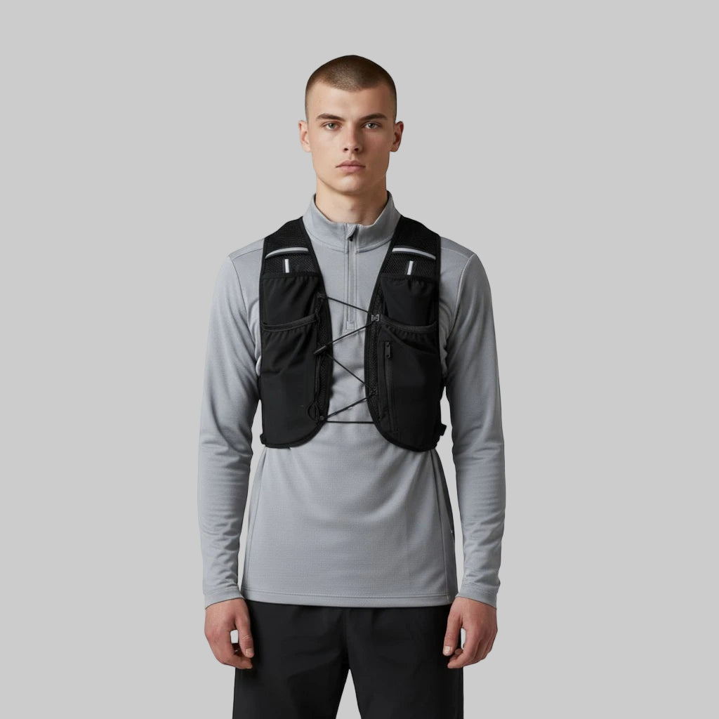 Mand iført sort løbevest over grå langærmet løbetrøje, set forfra